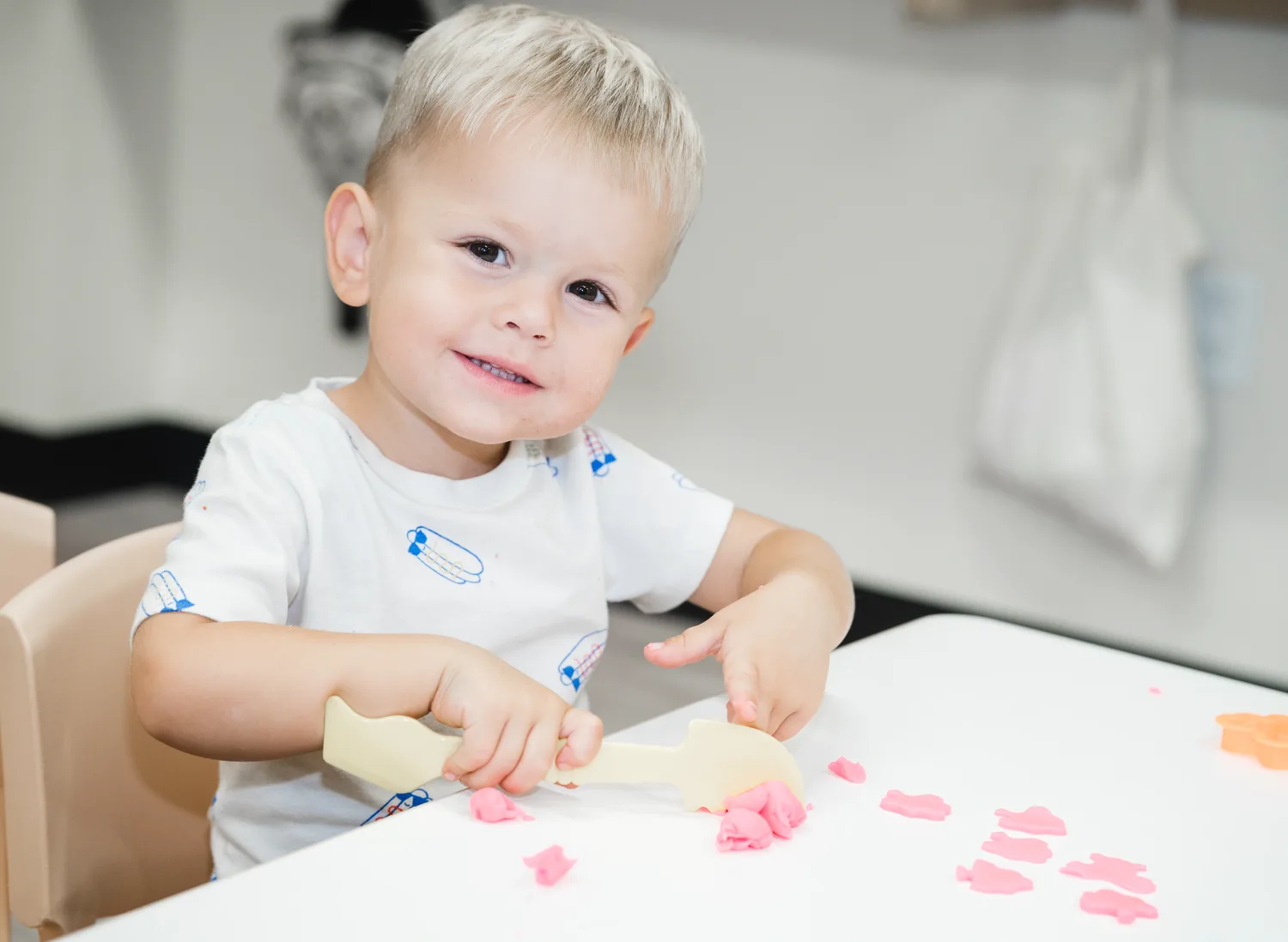 A smiling young child enjoying a hands-on table activity